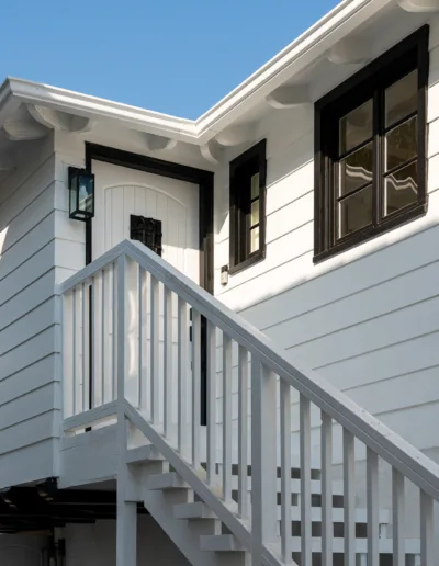 A white house with stairs leading up to it.