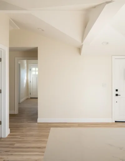 An empty room with white walls and wood floors.