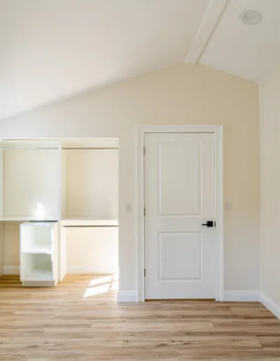 An empty room with white walls and wood floors.