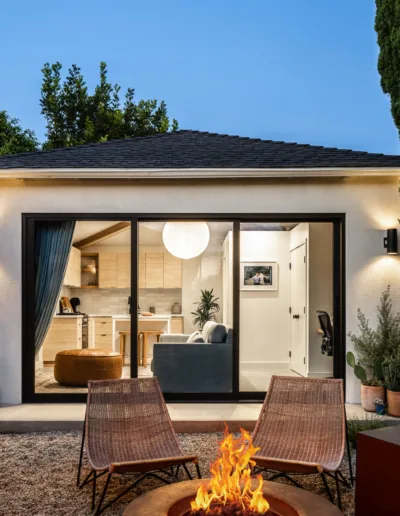 A small backyard with a fire pit and chairs.