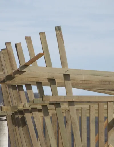 A wooden structure is being built on a hillside.