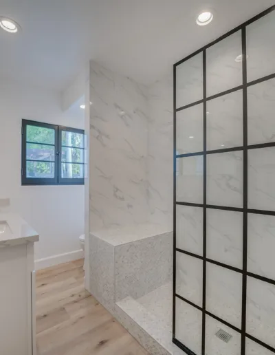 A white bathroom with a glass shower stall.