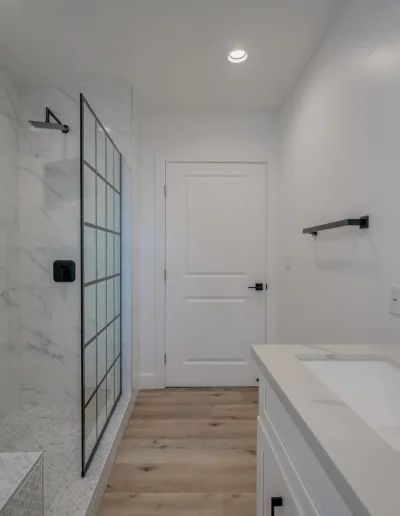 A white bathroom with a glass shower stall.