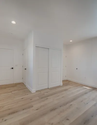 An empty room with white walls and wood floors.