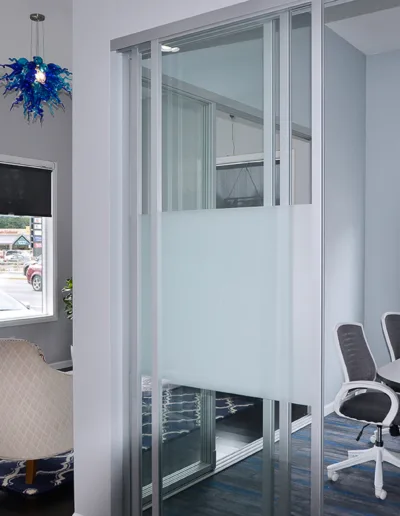 An office with a glass door and chairs.