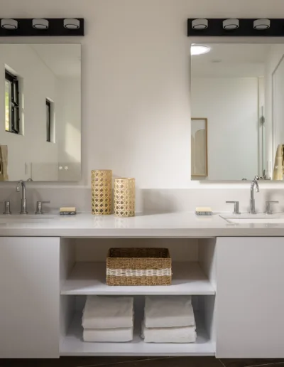 A white bathroom with two sinks and mirrors.