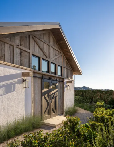 The exterior of a barn with a wooden door.