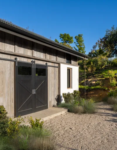 A barn with a black door and black siding.