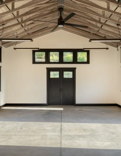 A large open space with a ceiling fan and wooden beams.