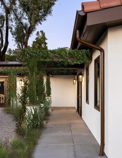 An entryway to a home with a pathway and trees.