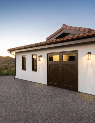 A house with a garage and a driveway at dusk.