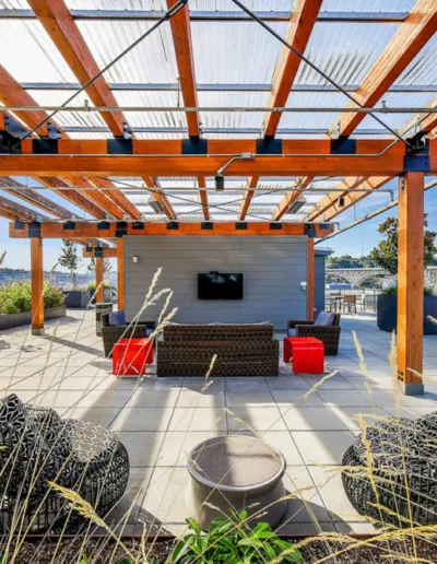 A rooftop patio with furniture and a tv.