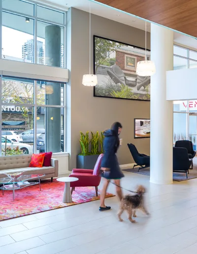 A woman walking her dog through a lobby.