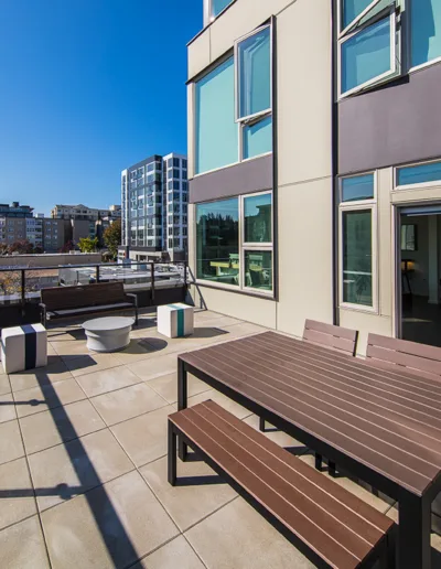 A balcony with a table and chairs and a view of the city.